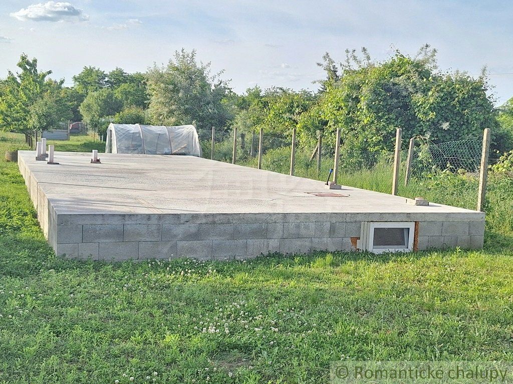 Rovinatý pozemok so základovou doskou na okraji podunajskej dedinky Moča